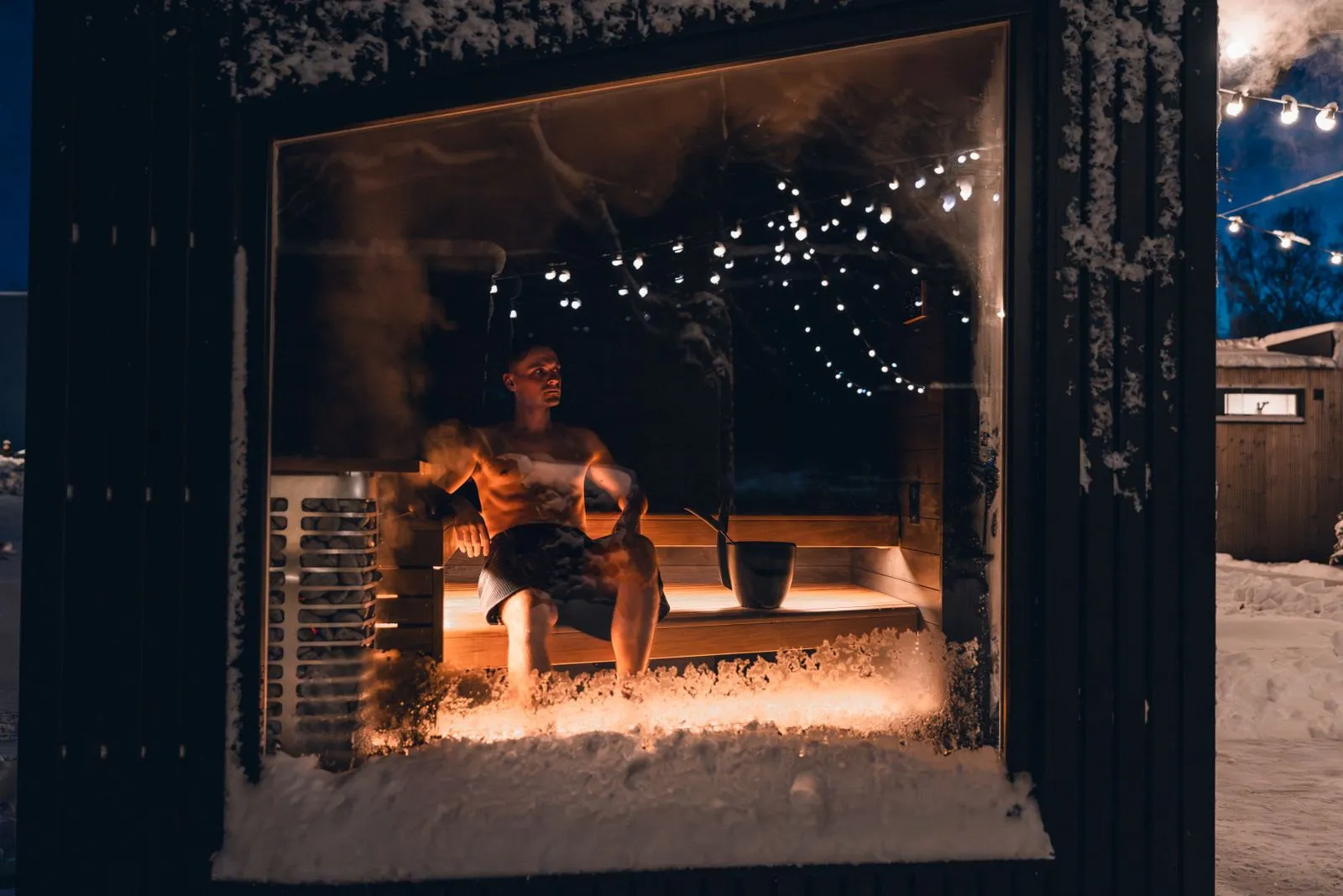 Cosy sauna interior lit warmly with a snowy scene implied outside