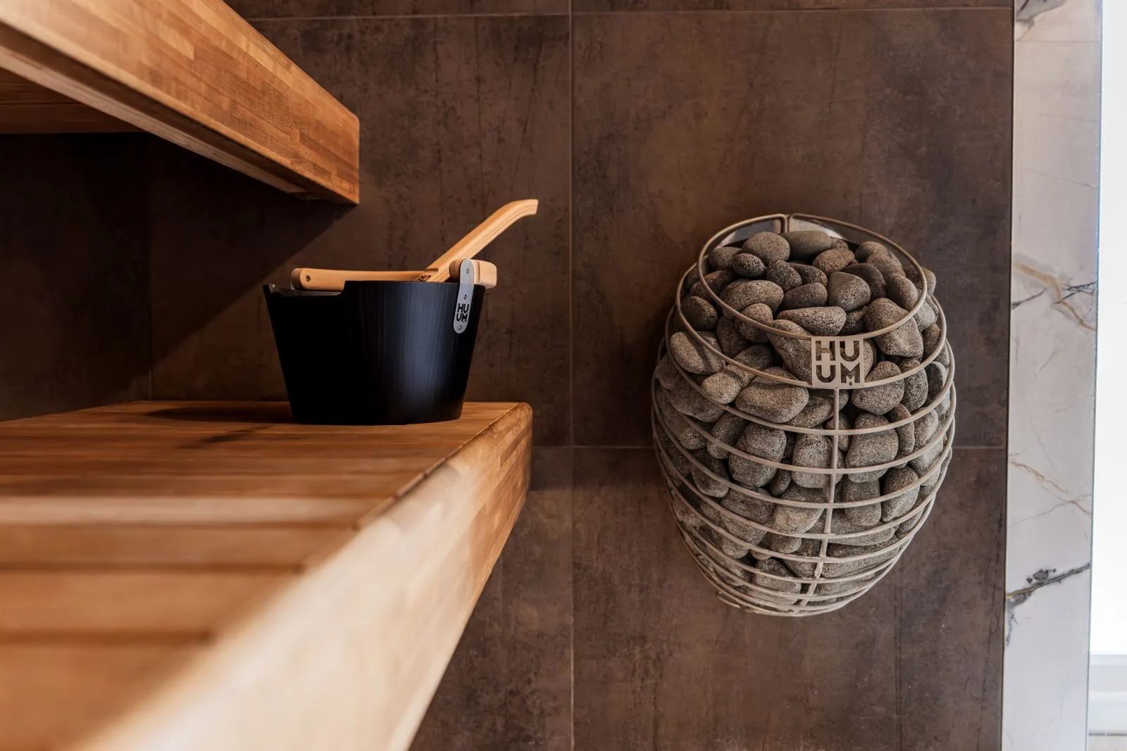 Modern Nordic sauna interior with a stone-topped heater