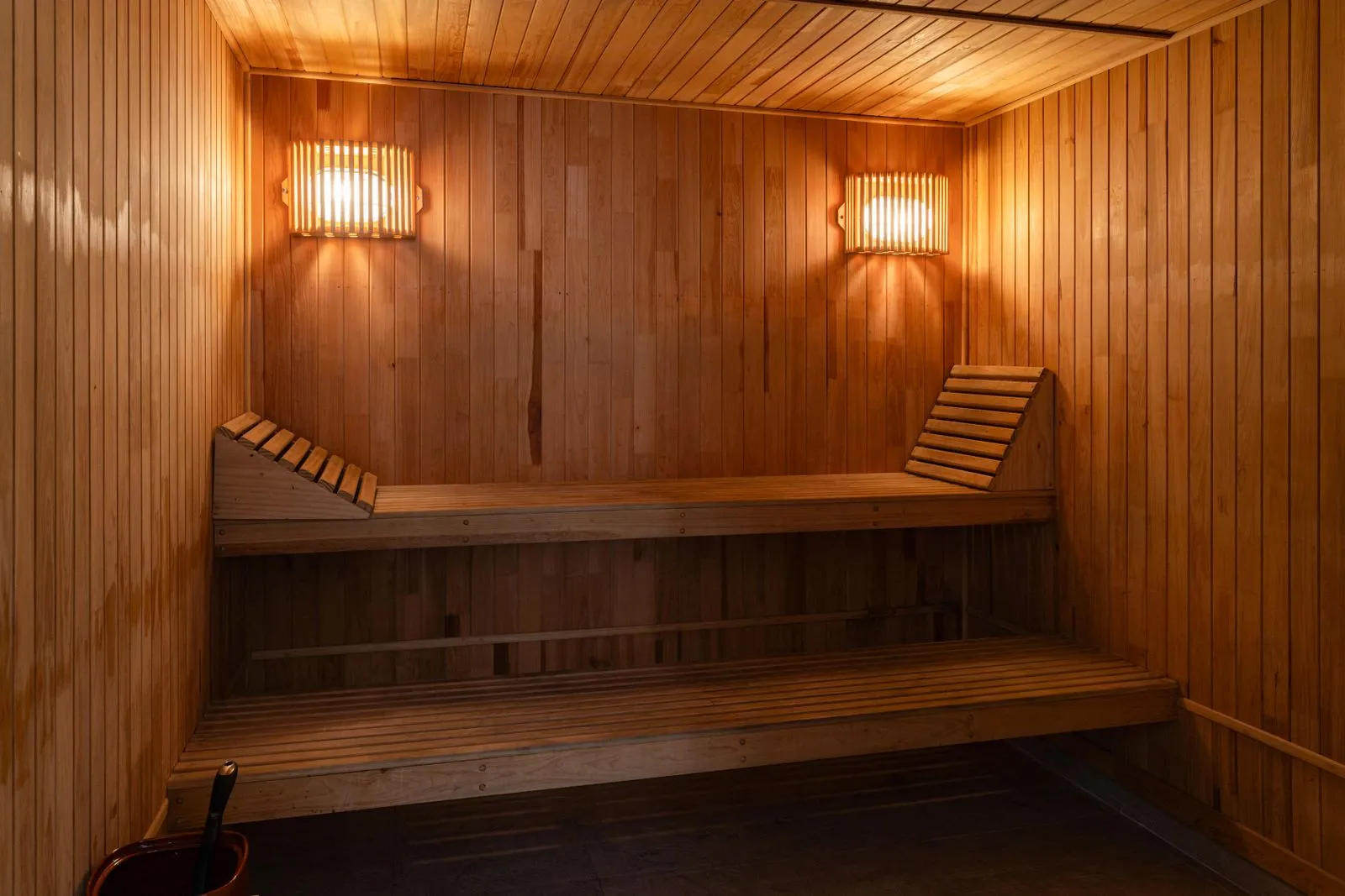 A cold plunge tub beside a steaming sauna in winter