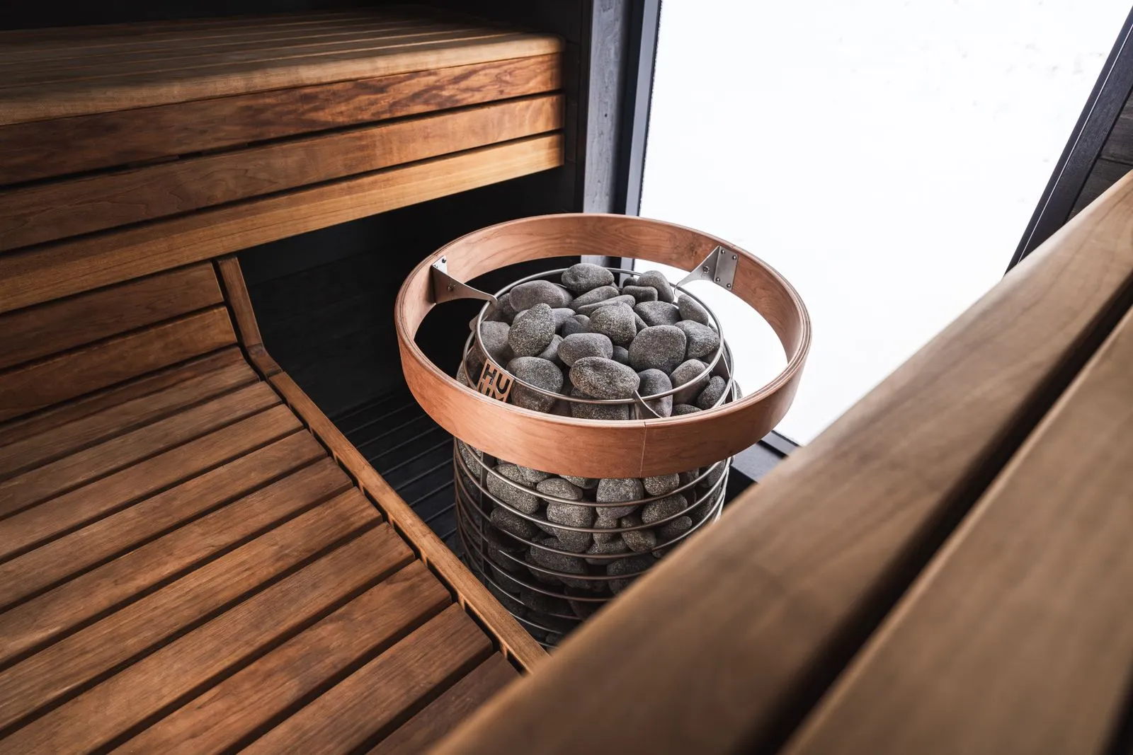 Dense dark peridotite sauna stones stacked on a heater