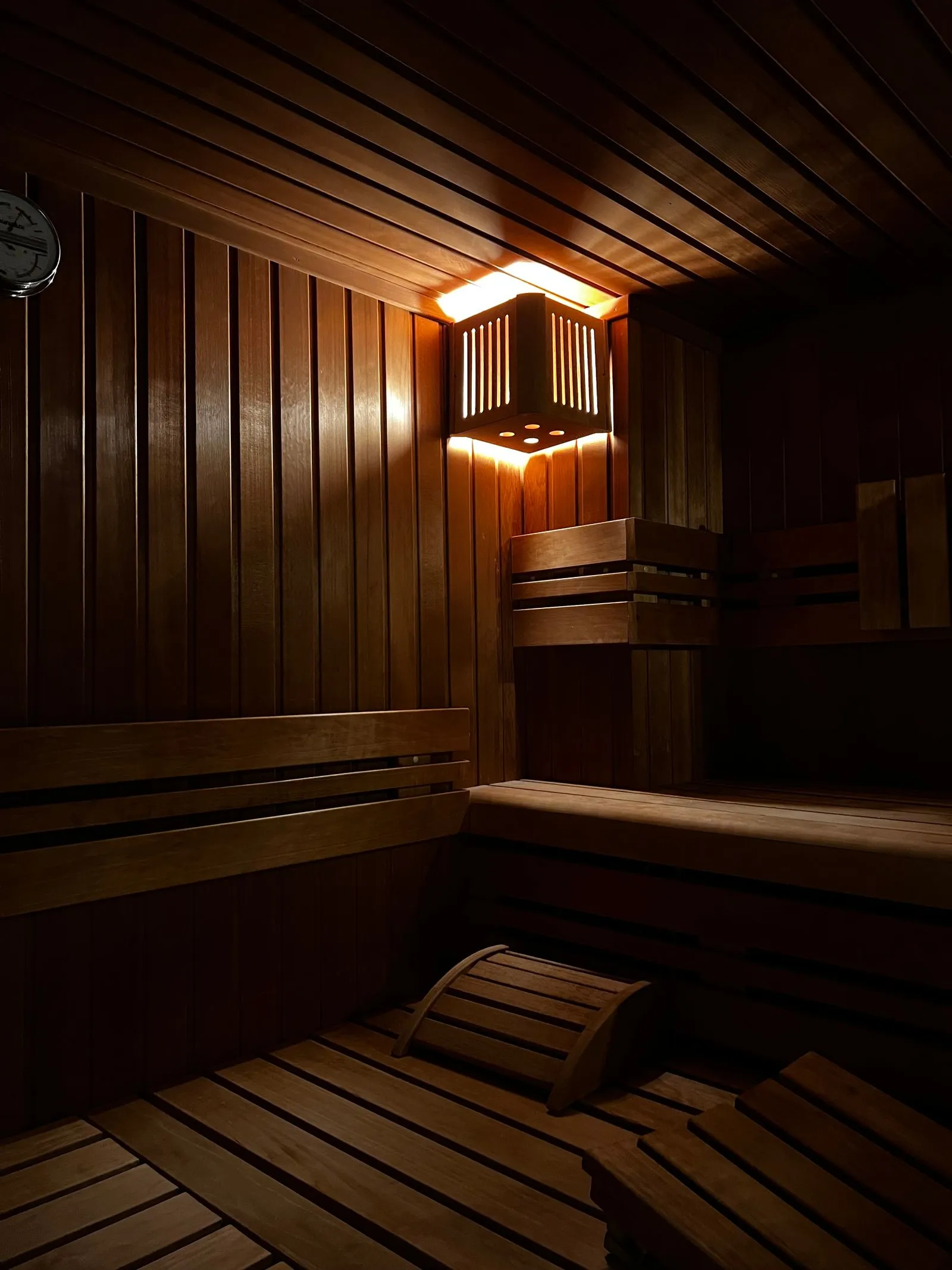 Small wood-lined sauna cabin fitted into a home interior