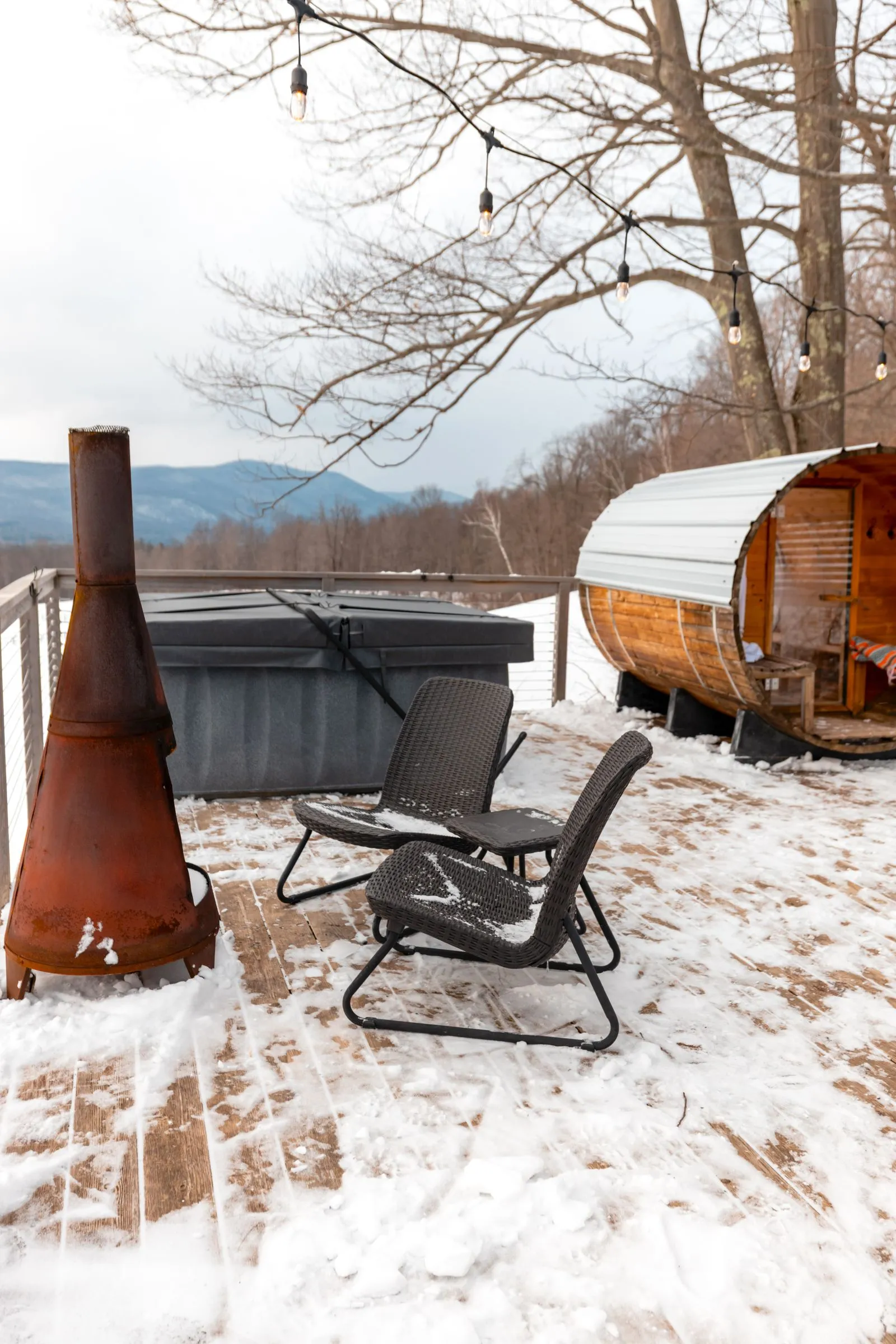 A snow-dusted outdoor sauna with a clear path to the door