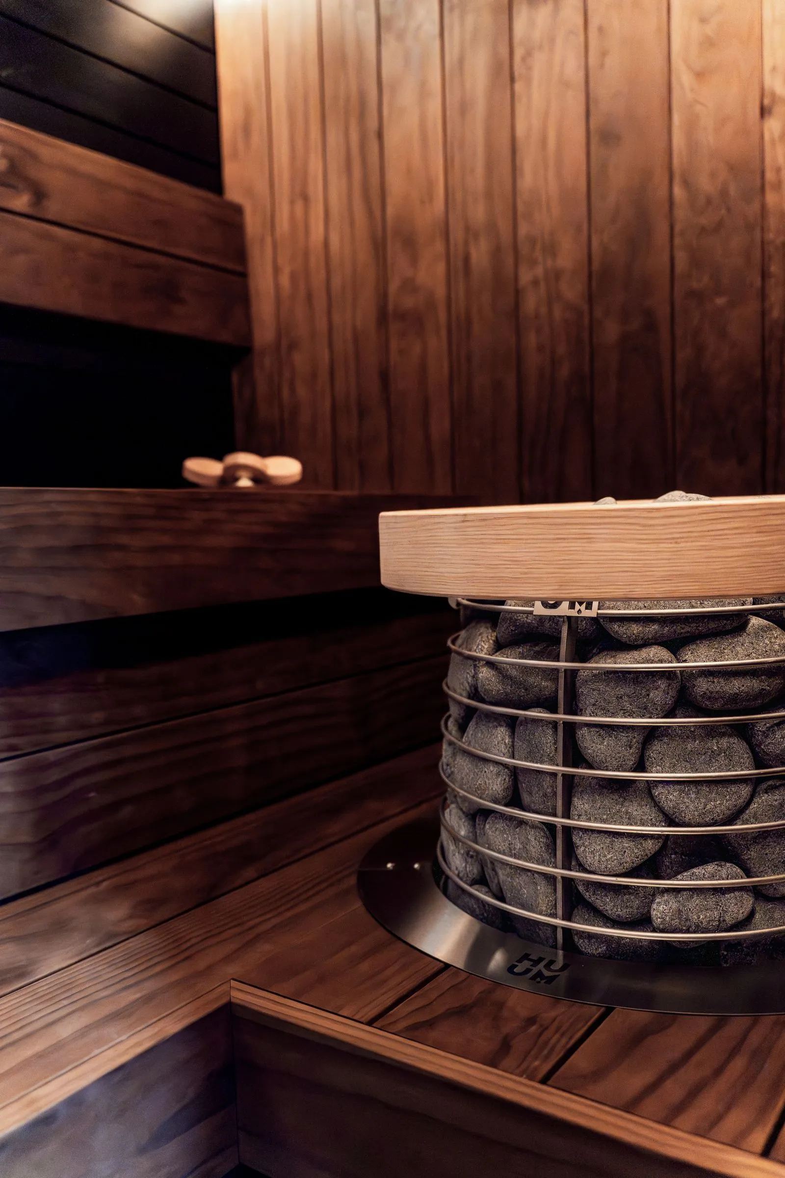 Close view of an electric sauna heater packed with dark stones