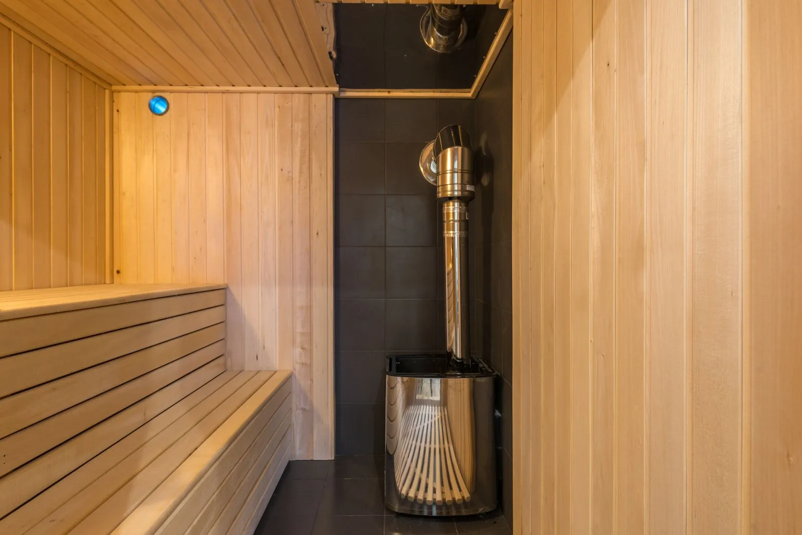 Soft indirect lighting glowing behind a sauna bench