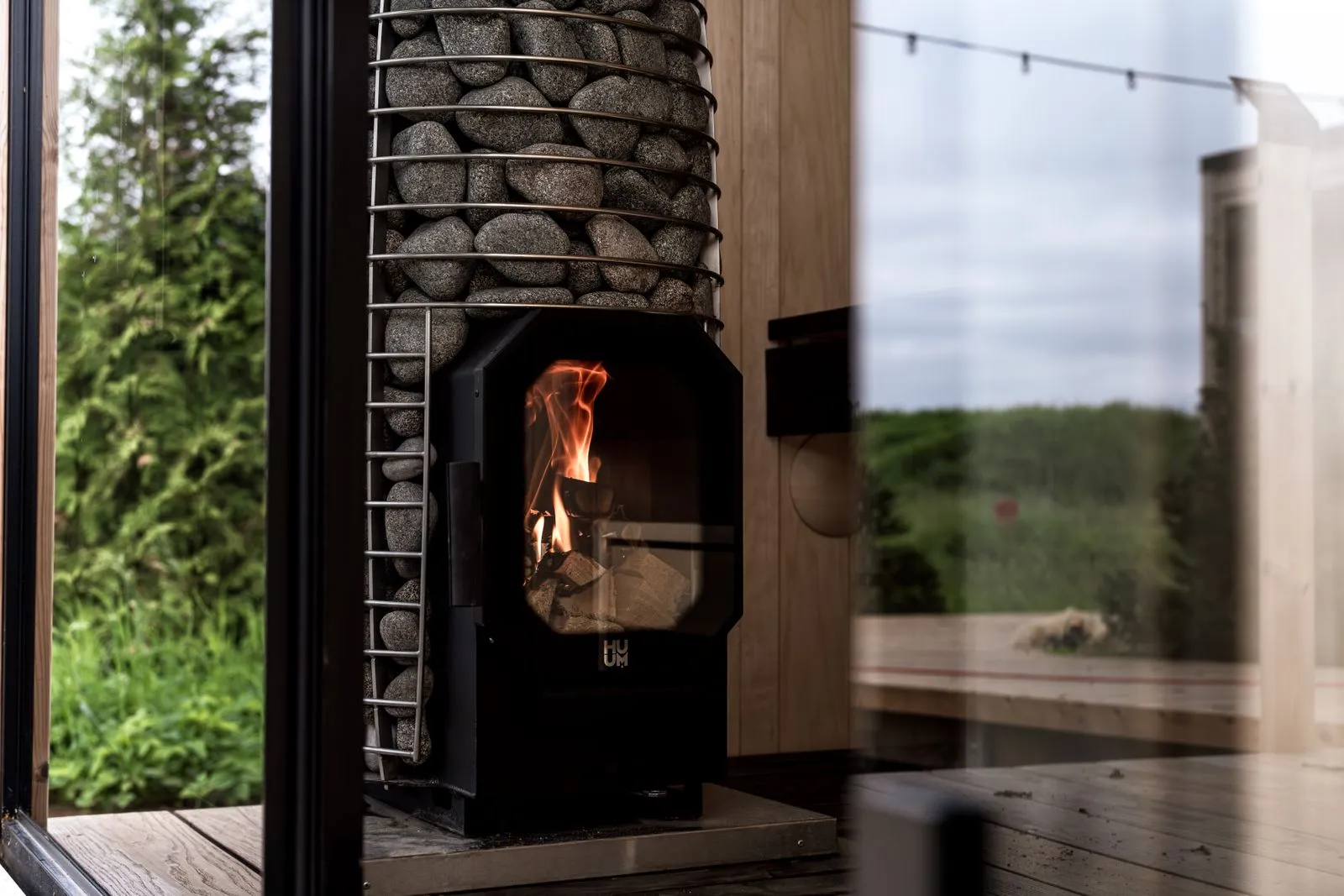 Electric sauna heater with a wooden guard rail installed in a modern sauna
