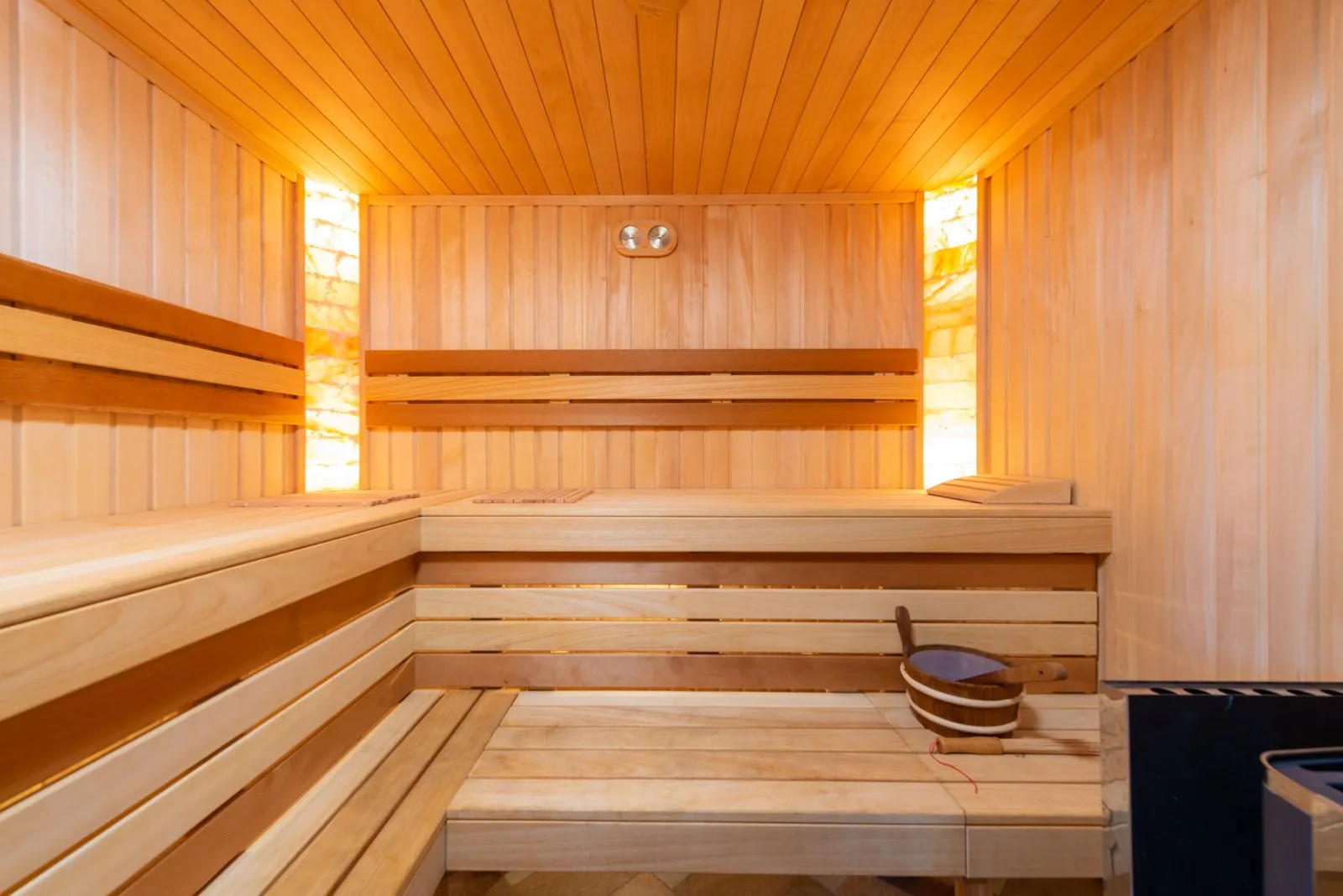 Empty wooden sauna interior with tiered benches and warm light